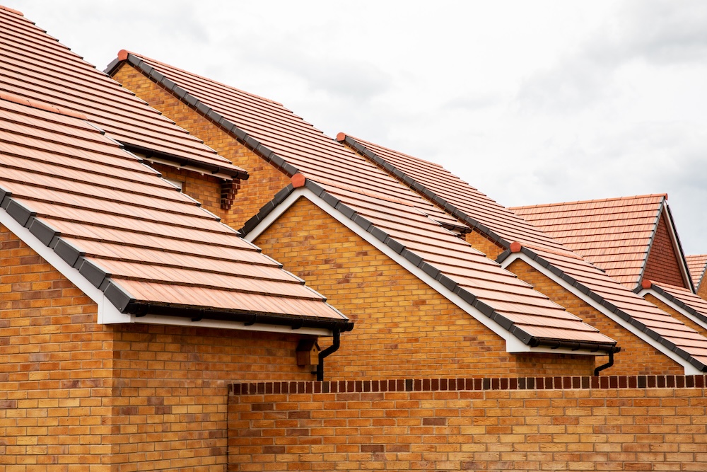 Exterior view of yellow brick row house with yellow roof tiles.,Harwell